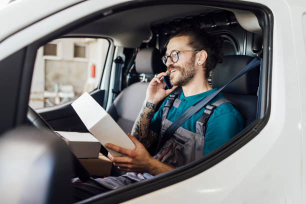 istock Young worker from a delivery service calling a customer to deliver him a package 1401629815