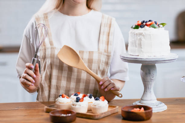 istock Pastry chef confectioner young caucasian woman with cake on kitchen table. 1401629839