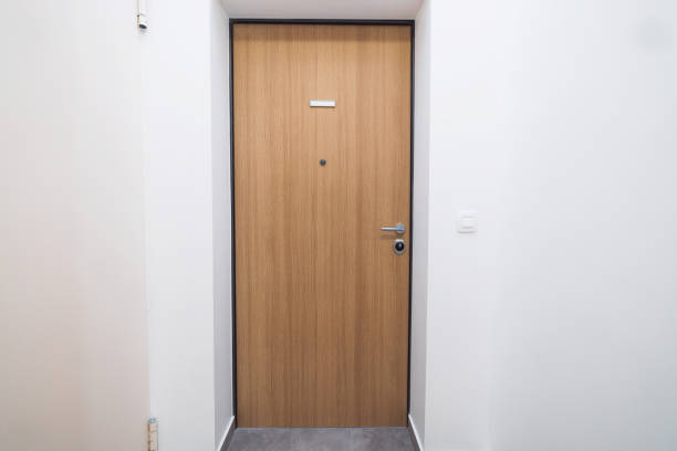 Wooden finish on the front doors leading into an apartment in a new apartment complex.