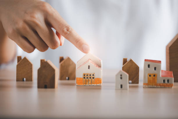 istock closeup woman finger pointing on beautiful home model 1401639477