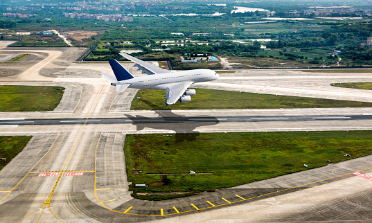 White passenger jet aircraft in flight. The plane takes off from the airport runway. Airplane aerial and side view.