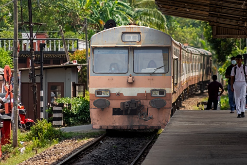 Maggona , Sri Lanka, March 24th 2022, Railway Department Class S8  Diesel multiple unit,  arrival to the Maggona station coast  line, some people walking in the platform,