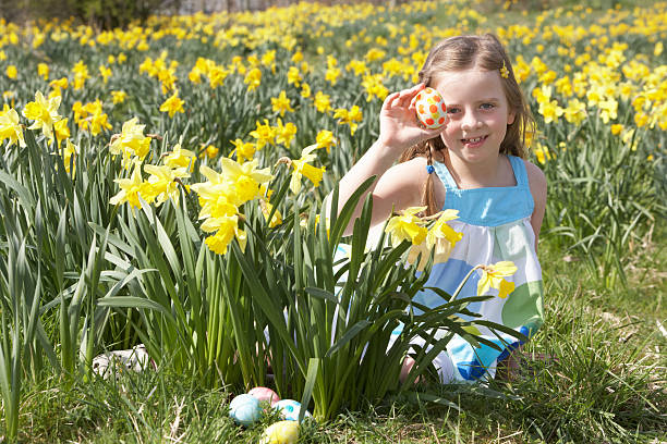 istock Girl On Easter Egg Hunt In Daffodil Field 140164631
