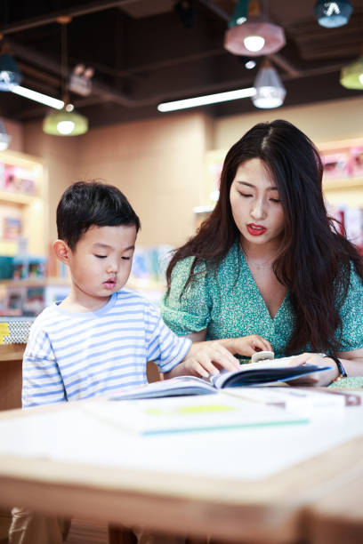 istock Mother and son reading together in a bookstore 1401650910