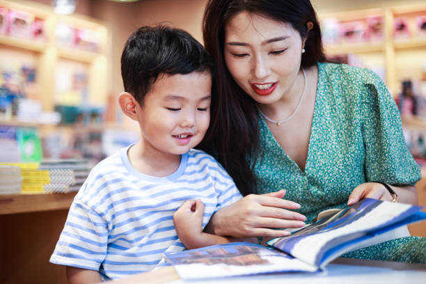 mãe e filho lendo juntos em uma livraria - picture book library preschool bookshelf - fotografias e filmes do acervo