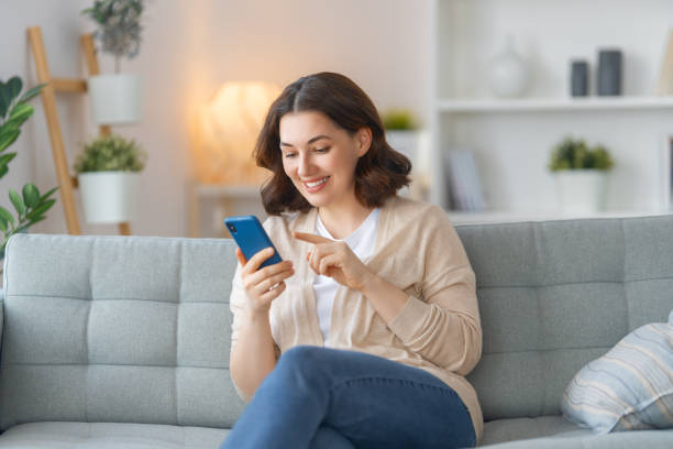 istock woman is using a phone sitting on a sofa 1401654851