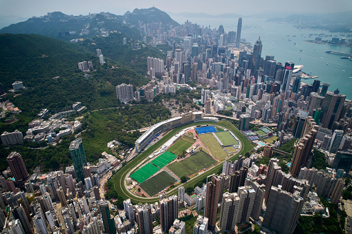 An aerial view of Happy Valley Racecourse, with the northwest of Hong Kong Island in the background.  Taken in May 2022.