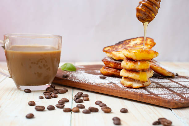 istock cheese pancakes (romanian papanasi) with coffee on a wood chopper. 1401662025