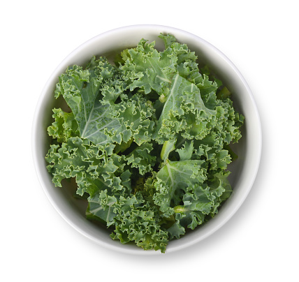 kale in white bowl isolated on white background. Top view