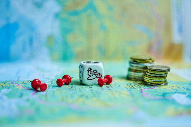 A child concentrates on a board game, carefully moving a red pawn among game pieces on a wooden table, conveying focus, play, and family activity indoors.