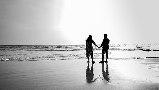 Couples enjoying at beach. watching sunset. black and white image