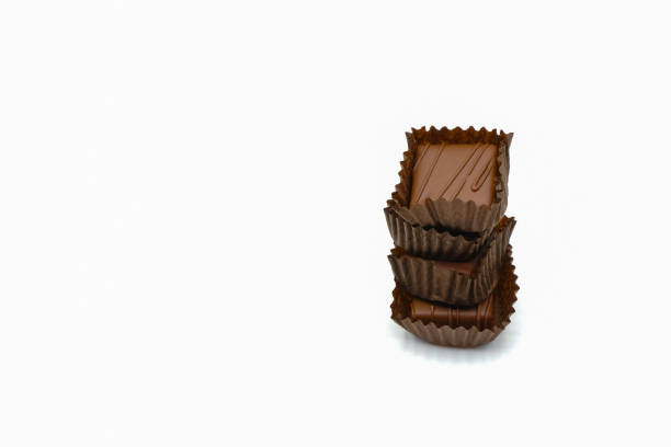 istock Stack of chocolate candies in paper cups on a white background. 1401665817