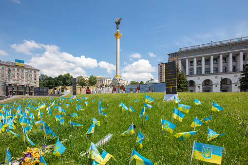 Kyiv, Ukraine - June 1, 2021: Grass decorated with small national flags near Independence Monument in Kyiv