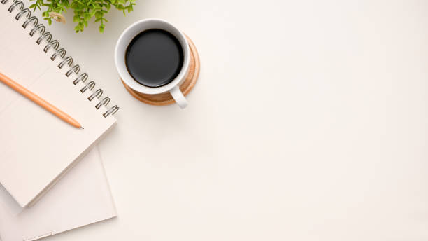 istock Modern workspace top view with a cup of coffee, pencil, notepad and copy space on white background. 1401669345
