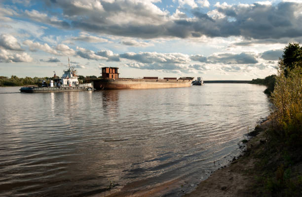 istock Tugs are dragging an old barge for scrap. Big river. Russia. 1401670318
