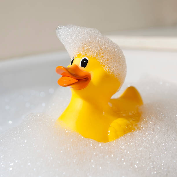 canard en caoutchouc recouverte de savon - duck toy photos et images de collection