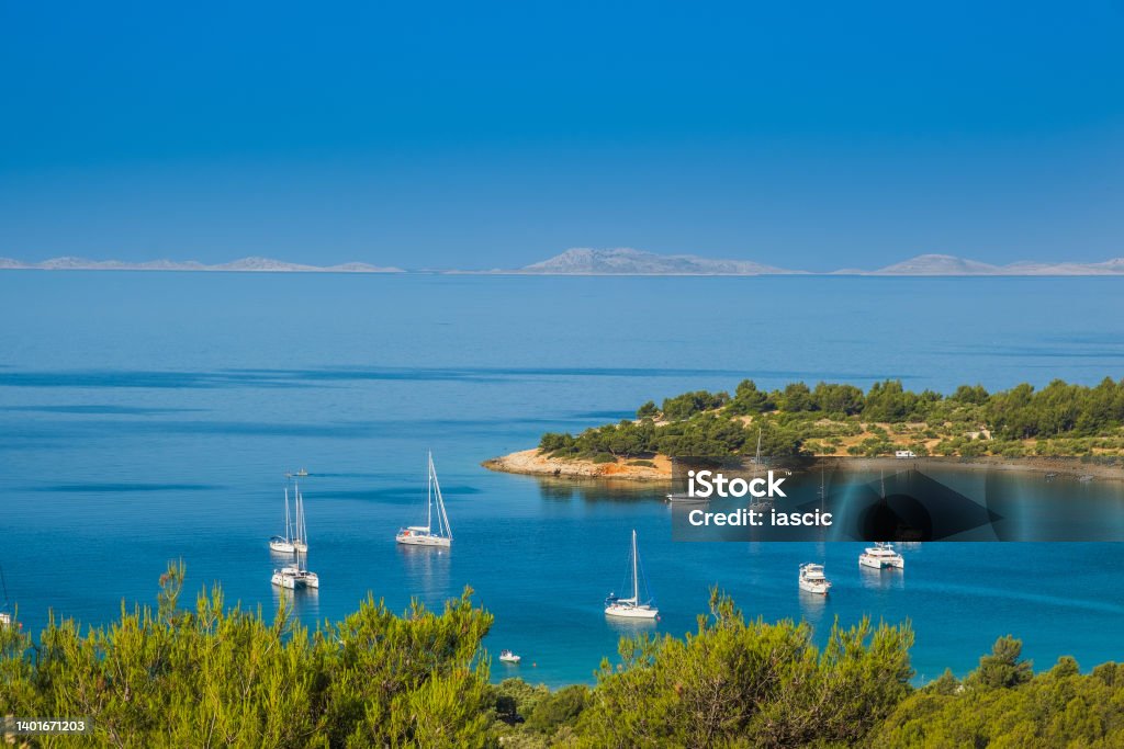 Panoramic view on Kosirina lagoon on Murter island in Croatia Panoramic view on Kosirina lagoon on Murter island in Croatia, anchored sailing boats and yachts on blue sea, Kornati archipelago in background Adriatic Sea Stock Photo