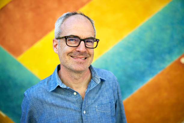 istock Cheerful mid 50s man standing against striped background 1401671529