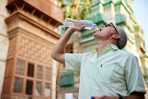 Turista masculino maduro bebiendo agua en Jeddah, Arabia Saudita photo