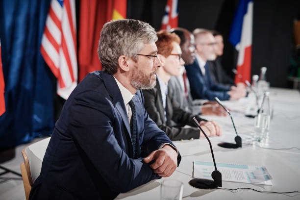 istock Group of people sitting at press conference 1401673971