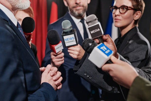istock Journalists interviewing businessman at conference 1401674203