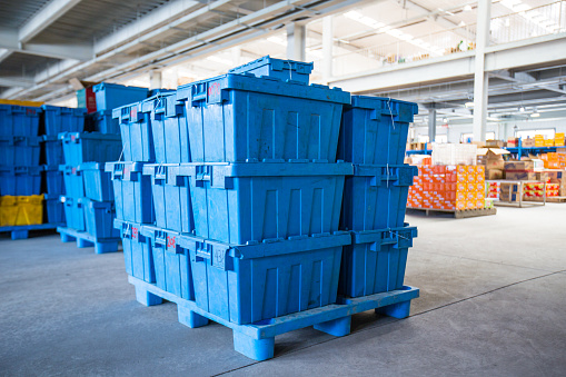 Stacked crates and cardboard boxes in warehouse, ready for transpor