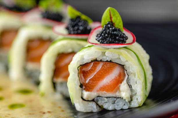 istock Sushi set of various products on a black stone plate. Blur background and selective focus 1401675705