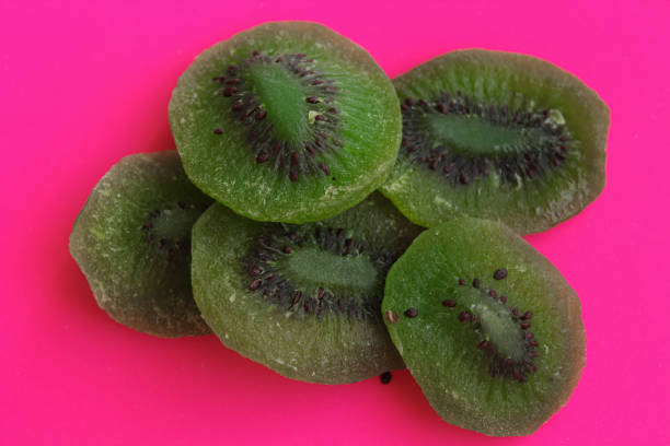 Close up of kiwi. Dried kiwi slices on a pink background.