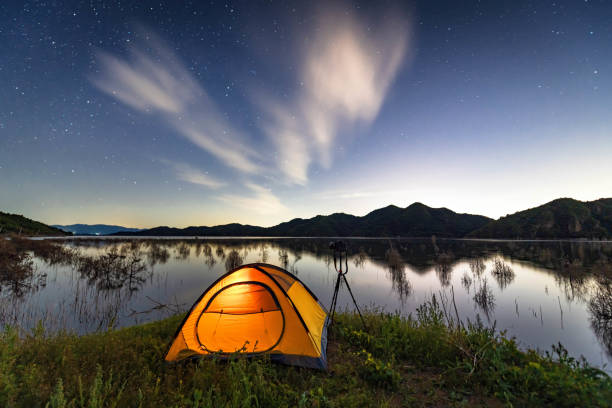 Camp tent by the lake under the starry sky