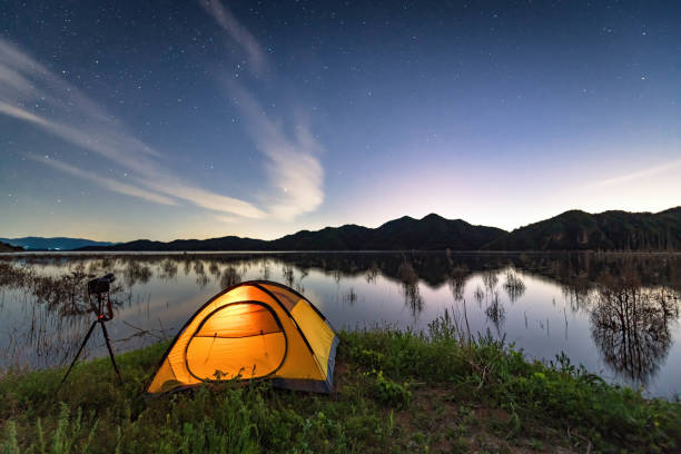 tienda de campaña junto al lago bajo el cielo estrellado - waterland fotografías e imágenes de stock