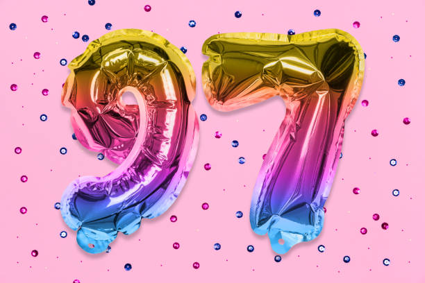istock Rainbow foil balloon number, digit ninety seven on a pink background with sequins. Birthday greeting card 1401678638