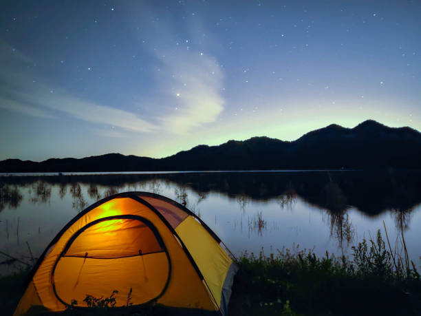 istock Camp tent by the lake under the starry sky