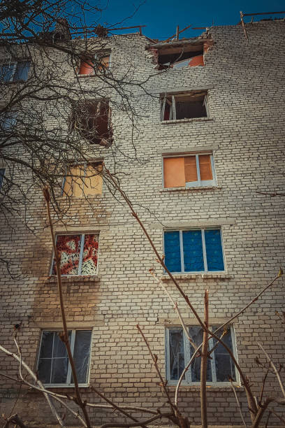 istock Destroyed facade of an apartment building with broken windows after being shot. 1401681139