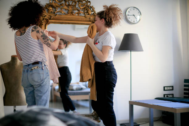 istock Two young women with curly hair having fun at home, trying sweaters on 1401681966