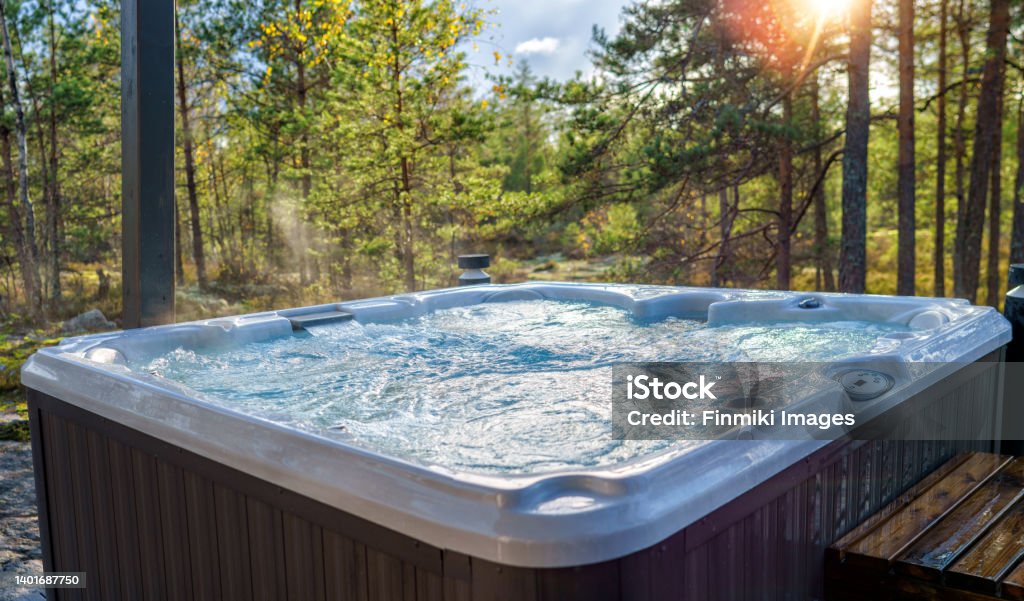 Warm hot tub A warm hot tub in a beautiful forest landscape at sunset. You can relax outdoors in nature while enjoying the warmth of the hot tub. Hot Tub Stock Photo
