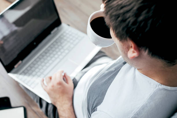 istock Young man using laptop sitting on floor in bedroom. Work from home. Stay home, stay safe, quarantine 1401690117