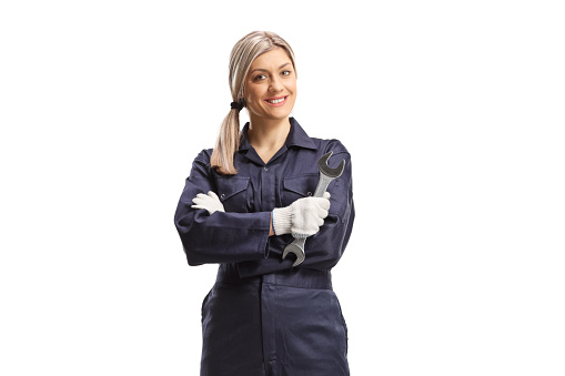 Smiling female worker in a uniform holding a wrench isolated on white background