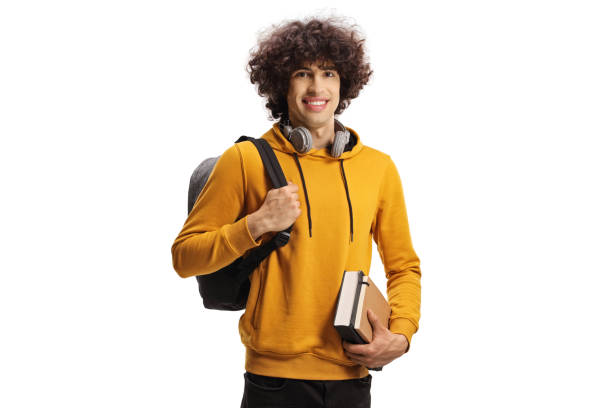 Smiling male student carrying a backpack and a book stock photo