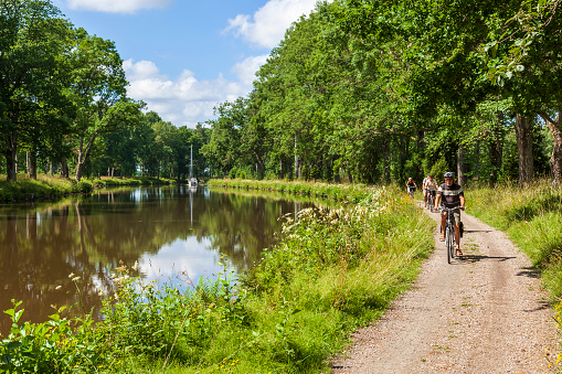 Göta canal, Sweden - July 17, 2017: Cyclists on a canal road on a beautiful summer day