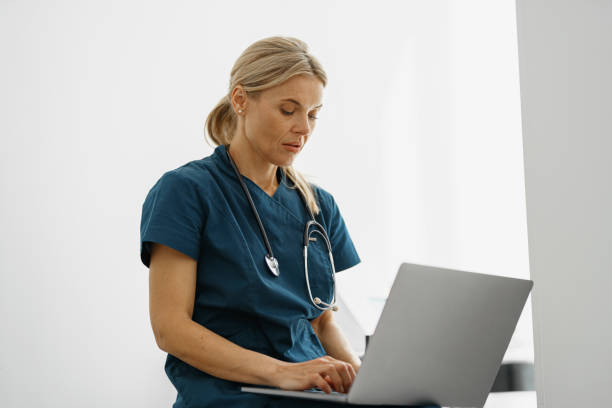 istock Female healthcare worker using laptop while working at doctor's office 1401693000
