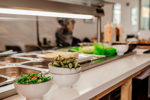 An expert female vegan sushi chef preparing tasty food in a local restaurant