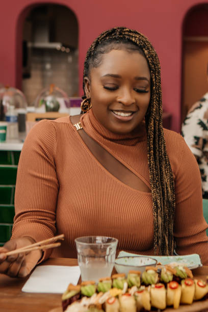 Beautiful woman enjoying Vegan Sushi in a local restaurant