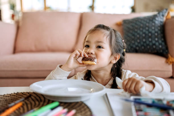 Cute little girl eating chocolate doughnut