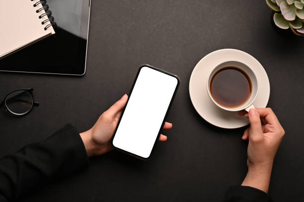 istock Top view, Workspace with a female hands, using smartphone and holding a cup of coffee 1401695288