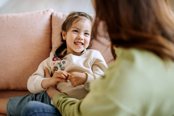 istock Cute little girl having fun with her mother on a sofa 1401696191