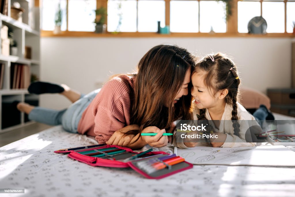 Mommy loves you the most Mother and daughter bonding while drawing in their cozy bedroom Parent Stock Photo
