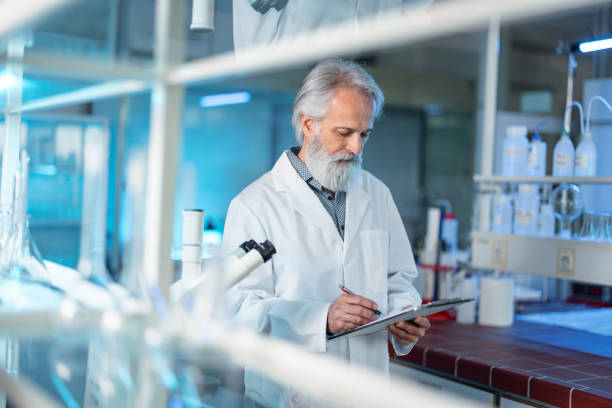 istock Senior Professional Scientist Taking His Notes In A Modern Laboratory 1401699317