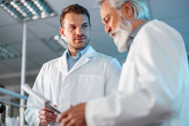 istock Male Researcher With Colleague Discussing Over Diary 1401699343