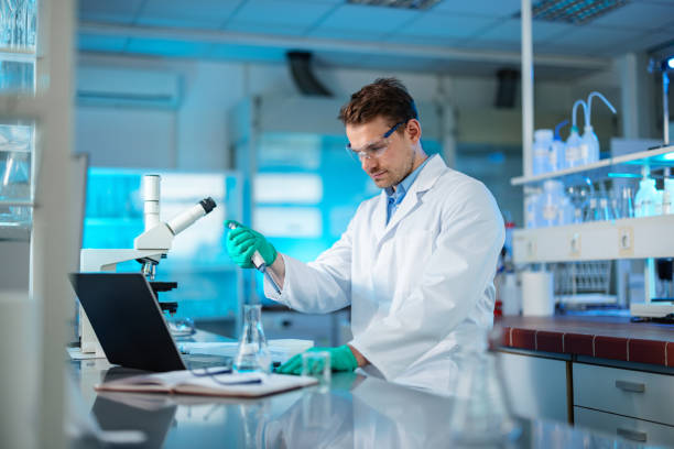 istock Caucasian Biochemist Mixing Liquid Chemical Using Pipette 1401699346