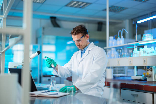 istock Caucasian Biochemist Mixing Liquid Chemical Using Pipette 1401699352